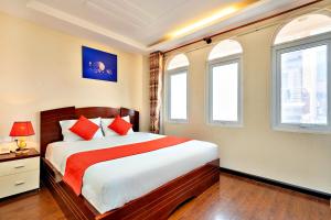 a bedroom with a bed and two windows at HANZ The Beautiful Hotel Bui Vien Walking Street in Ho Chi Minh City