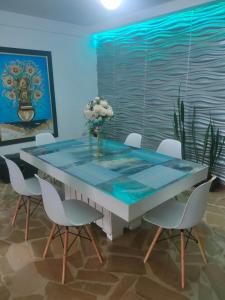 a dining room with a glass table and chairs at Bryslaungeguayaquil in Guayaquil