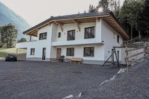 una casa bianca con un'auto parcheggiata davanti di Alpin 1100 a Steeg