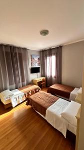 a hotel room with two beds and a television at Nuova Locanda Belvedere in Marghera