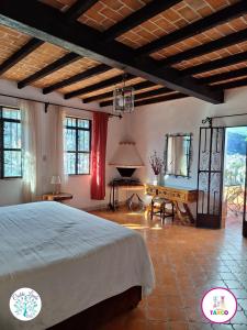 a bedroom with a bed and a table and windows at Hotel Cielito Lindo, Taxco in Taxco de Alarcón