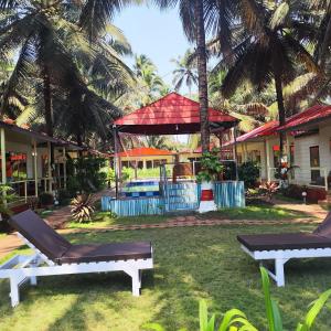 a yard with two lounge chairs and a house at The Sunbliss Cottages in Morjim