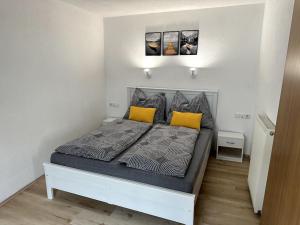 1 dormitorio con 1 cama con 2 almohadas amarillas en Maisonette-Apartment mit großer Terrasse im Zentrum von Bregenz, en Bregenz