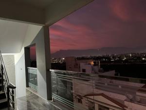 a balcony with a view of a city at night at Tirupati Homestay - Ragunatha Resorts - 3BHK AC Apartments for large families - Best location - Flyover to Alipiri gate - Modular Kitchen - Super fast WiFi - Android TV - 250 Jio Channels - Easy access to visit all Temples in Tirupati