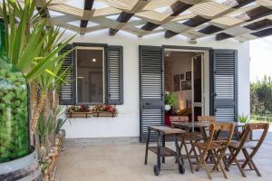 a patio with a table and chairs under a wooden ceiling at BeB Nonno Baffo in Avola