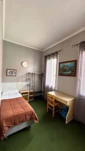 Schlafzimmer mit einem Bett, einem Schreibtisch und einem Tisch in der Unterkunft Nuova Locanda Belvedere in Marghera