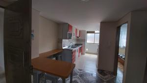 a small kitchen with red cabinets and a table in it at Edificio K&C in Sogamoso