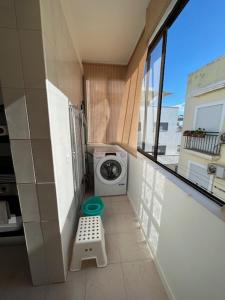 a laundry room with a washing machine and a window at APARTAMENTO Casa Hortense in Olhão