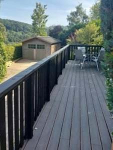 une terrasse en bois avec une table et une chaise. dans l'établissement 2 bed barn with spectacular views - Wye Valley, à Symonds Yat