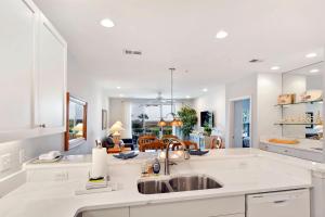 a kitchen with a sink and a living room at Windward Point 109 in Saint Simons Island