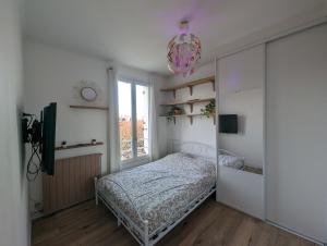 1 dormitorio con cama y ventana en Charmant appartement à 2 pas de Paris, en Saint-Maur-des-Fossés