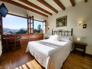 a bedroom with a bed and a large window at La Biesca Sebreñu in Ribadesella