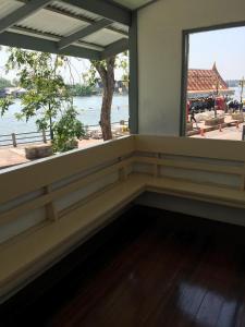 a room with a large window with a view of the water at Baan Songsri in Amphawa