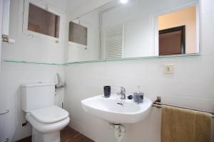 uma casa de banho com um WC, um lavatório e um espelho. em Apartamento céntrico en Sant Feliu de Guíxols em Sant Feliu de Guíxols