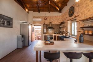 een grote keuken met een groot eiland in een kamer bij Wood and Stone Ηouse in Aegina Town