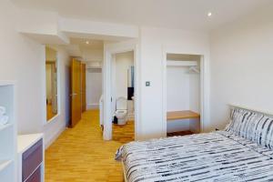 a bedroom with a bed and a bathroom with a toilet at City Centre Sleeps up to 6 in Nottingham