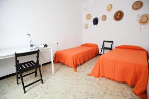 a room with two beds and a desk and a table at Apartamento céntrico en Sant Feliu de Guíxols in Sant Feliu de Guíxols