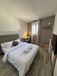 ein Schlafzimmer mit einem großen weißen Bett mit Handtüchern darauf in der Unterkunft Hôtel-Restaurant Le Hauteville in Hauteville-Lompnes