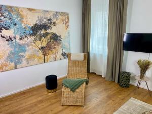 salon z krzesłem i obrazem na ścianie w obiekcie discovAIR Eisenach - 3-Zi- Apartment Matteo- Schwimmbad-Nah mit Netflix w mieście Eisenach