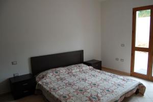 a bedroom with a bed with a comforter and a window at Nuovissimo appartamento con veranda vista mare a Maladroxia C63 in Maladroscia