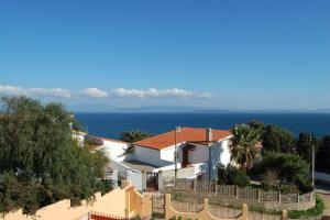 ein weißes Haus mit einem Zaun vor dem Meer in der Unterkunft Nuovissimo appartamento con veranda vista mare a Maladroxia C63 in Maladroscia
