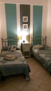 una camera con due letti e un tavolo con una lampada di Azzurro Mare - Cornino a Custonaci