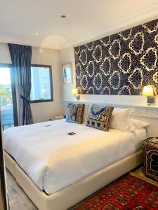 a large white bed in a room with a window at Dar Nour in Tangier