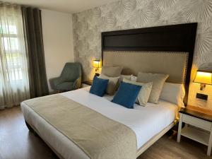 波托馬林的住宿－VISTALEGRE Hotel-Spa，卧室配有带蓝色枕头的大型白色床