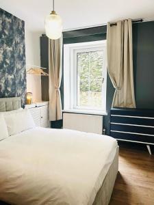a bedroom with a large white bed and a window at Mountain View Home - Dolgellau in Dolgellau