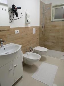 een badkamer met een toilet, een wastafel en een douche bij Mosa House in Aci Castello