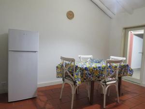y cocina con mesa, sillas y nevera. en Mosa House, en Aci Castello
