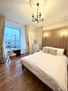 a bedroom with a large bed and a chandelier at Mountain View Home - Dolgellau in Dolgellau