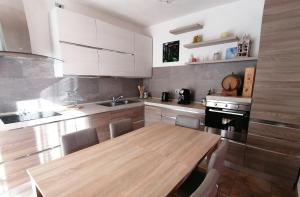a kitchen with a wooden table and a kitchen with white cabinets at Ulivi on the lake in Dongo
