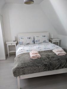 a bedroom with a bed with two towels on it at Craigmile Cottage in Fraserburgh