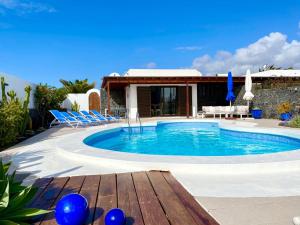 ein Swimmingpool mit Stühlen und ein Haus in der Unterkunft Villa Vista Verano in Playa Blanca