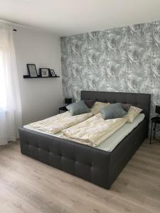 a large bed in a bedroom with a wall at Am Kienbusch - Erdgeschoss in Annweiler am Trifels
