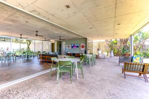 a dining room with tables and chairs and windows at 10 Dash Apartment, Dunkirk in Sheffield Beach