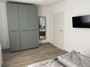 a bedroom with a bed and a flat screen tv at Am Kienbusch - Erdgeschoss in Annweiler am Trifels
