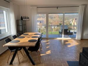 una sala da pranzo con tavolo in legno e ampia finestra di Am Kienbusch - Erdgeschoss ad Annweiler am Trifels