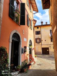 an orange building with doors and flowers in a courtyard at B&B Le Fate Del Lago in Lierna