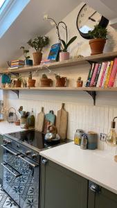 una cocina con estanterías con macetas. en Boutique Townhouse, en Christchurch