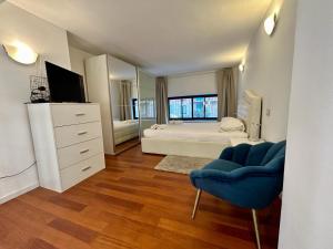 1 dormitorio grande con 1 cama y 1 silla azul en Kibilù - Via Tolmezzo - Ospedale San Raffaele - Stazione di Lambrate, en Milán