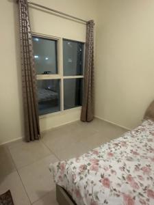 a bedroom with a bed and a window at Reflections Ajman-Home Away Home-Best property for stay in Ajman 