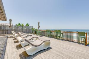 a row of chairs on a boardwalk next to the ocean at 10 Dash Apartment, Dunkirk in Sheffield Beach