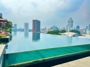 a large swimming pool with a city skyline in the background at Suite Opus Kuala Lumpur in Kuala Lumpur