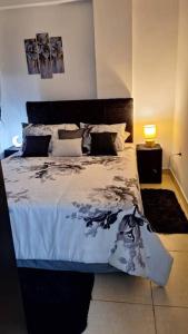 a bedroom with a bed with a black and white comforter at Departamento lujoso,confortable in San Lorenzo