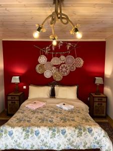 a bedroom with a large bed with a red wall at Petrameli in Karpenisi