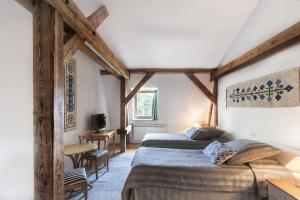 2 łóżka w pokoju z drewnianymi belkami stropowymi w obiekcie Pałac Nieznanice Zabytek Gościnny ze SPA w mieście Nieznanice