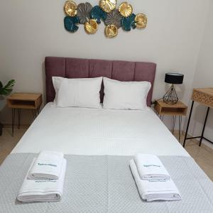 a bed with two towels on top of it at Tsimas House in Potamia +9 photos