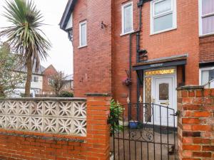 a brick house with a gate and a fence at South Bay Beach House in Bridlington